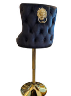 A black and gold bar stool with a tufted backrest and a gold lion knocker.