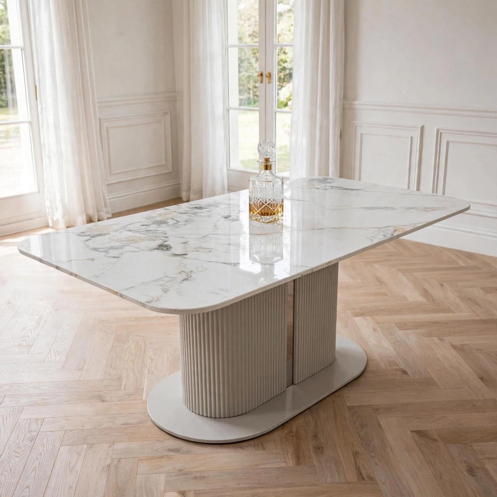 Cream marble pedestal dining table with fluted base in bright dining room – luxury UK