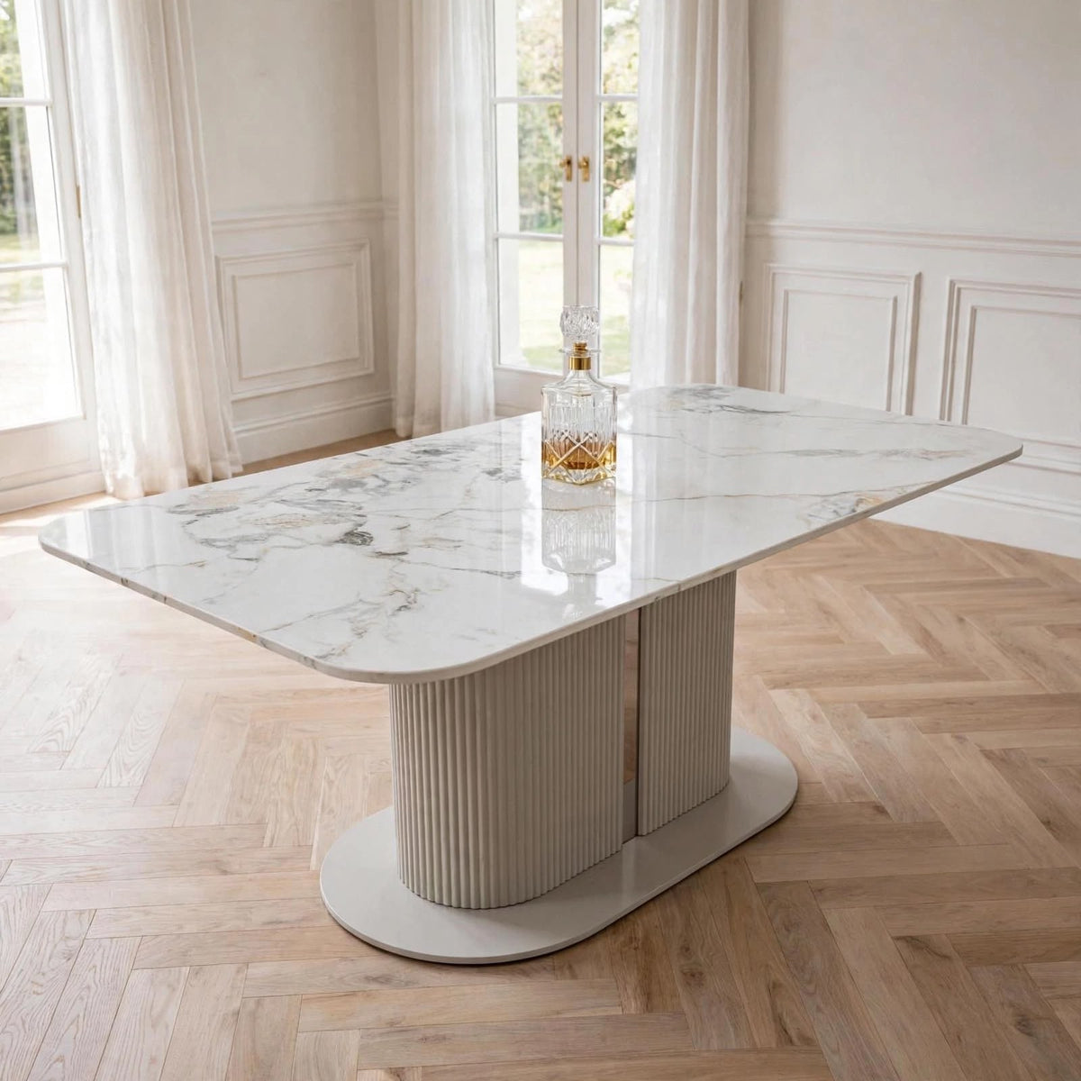 Cream marble pedestal dining table with fluted base in bright dining room – luxury UK