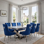 Close-up of navy blue velvet Majestic dining chair beside a light grey marble London table