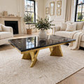 Ravello black marble and gold coffee table with gold veining and sculptural sunburst gold bases in luxury living room