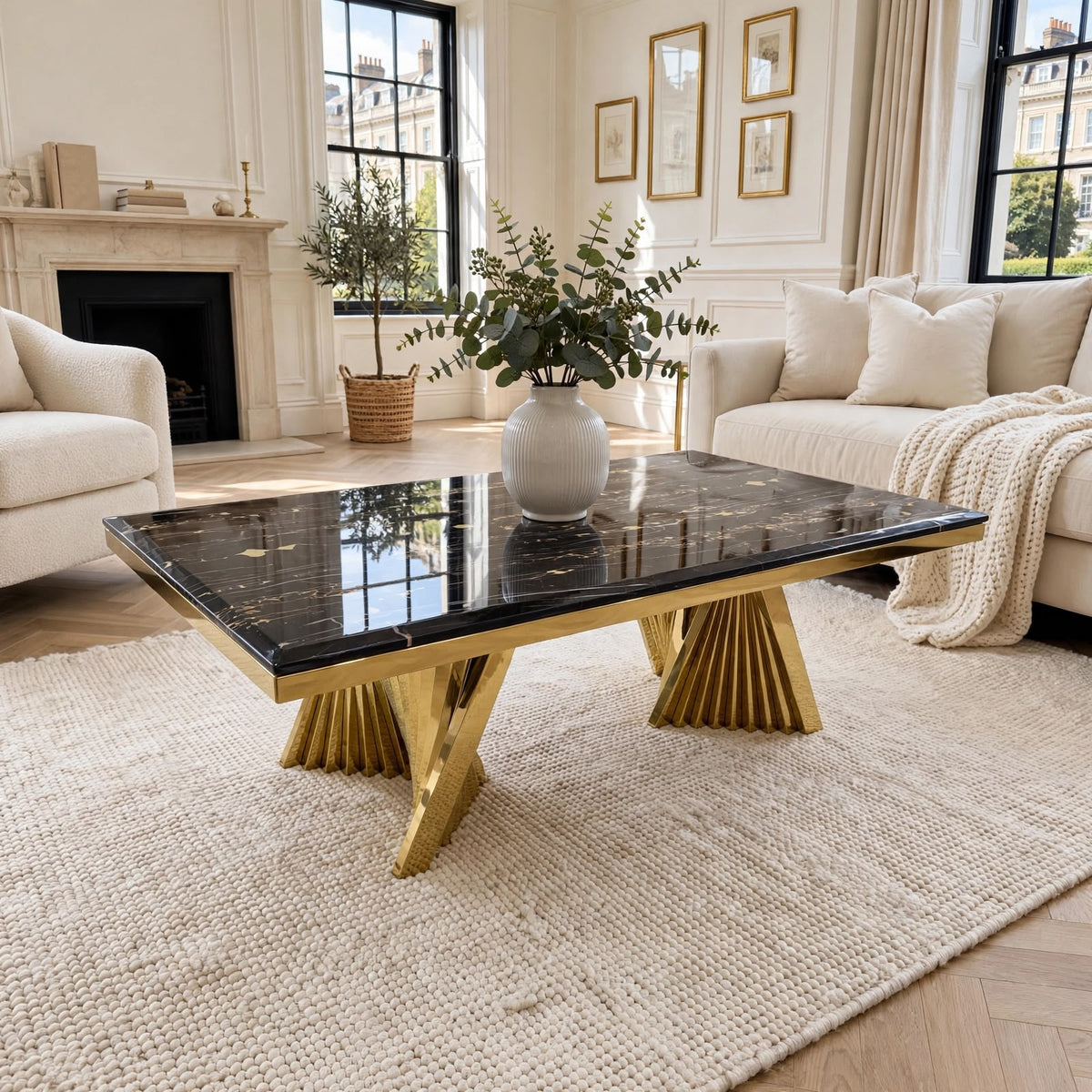 Ravello black marble and gold coffee table with gold veining and sculptural sunburst gold bases in luxury living room