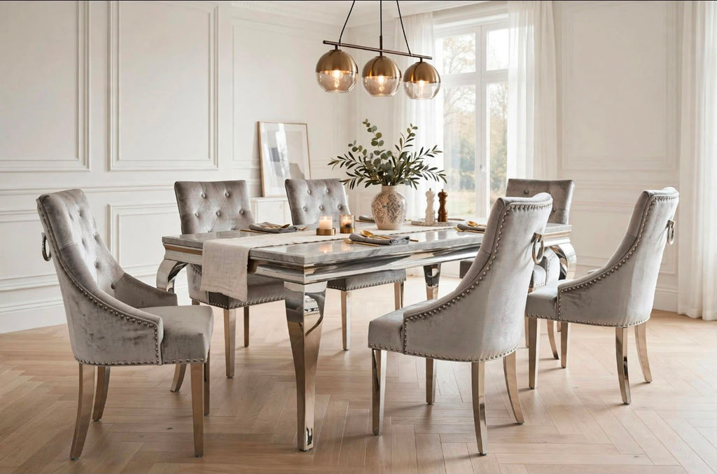 Louis light grey marble dining table with polished chrome base and six silver velvet Jessica ring knocker chairs in a white panelled dining room