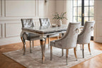 Light grey marble dining table with curved chrome Louis legs and four silver velvet Jessica chairs on a soft grey rug
